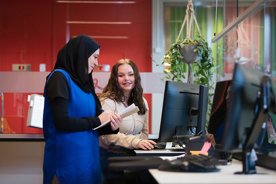 Två elever på hotell- och turismprogrammet i en reception